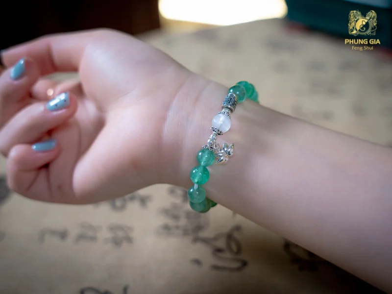 Vòng tay Tam Tai Dâu Tây Xanh được chế tác từ đá dâu tây xanh, đá Moonstone kết hợp cùng charm Hoa Sen Phú Quý và Charm bạc khắc quẻ Trạch Sơn Hàm